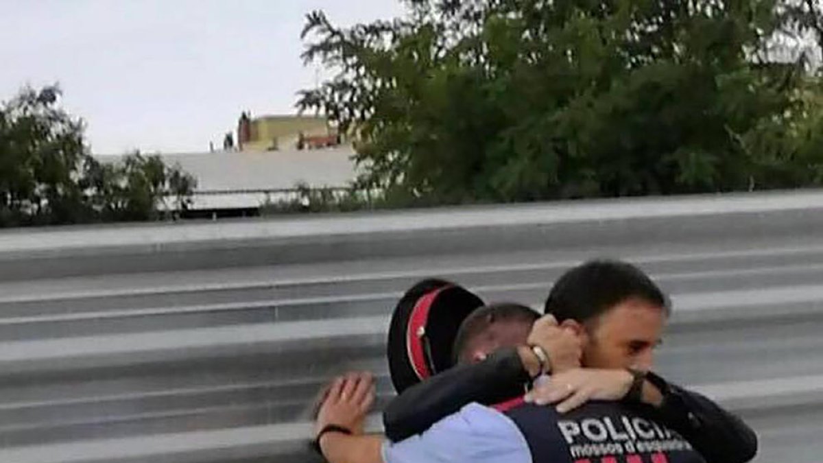 Un home consola un mosso després dels disturbis a Cappont.