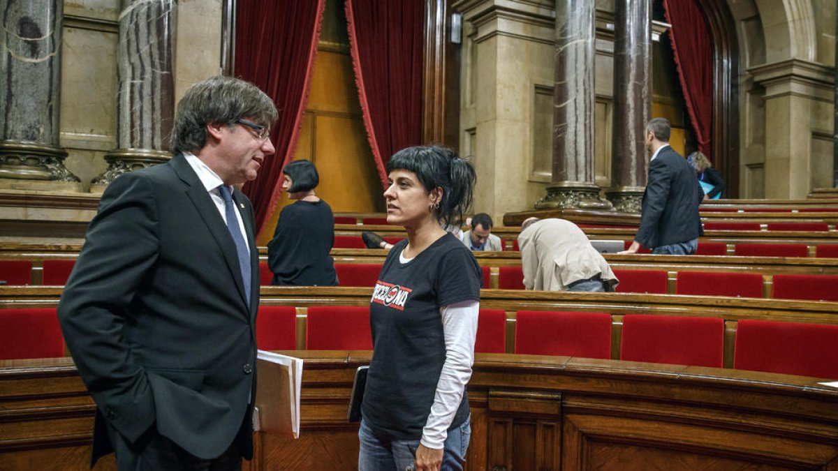 Carles Puigdemont y Anna Gabriel conversan en la sala de plenos del Parlament.
