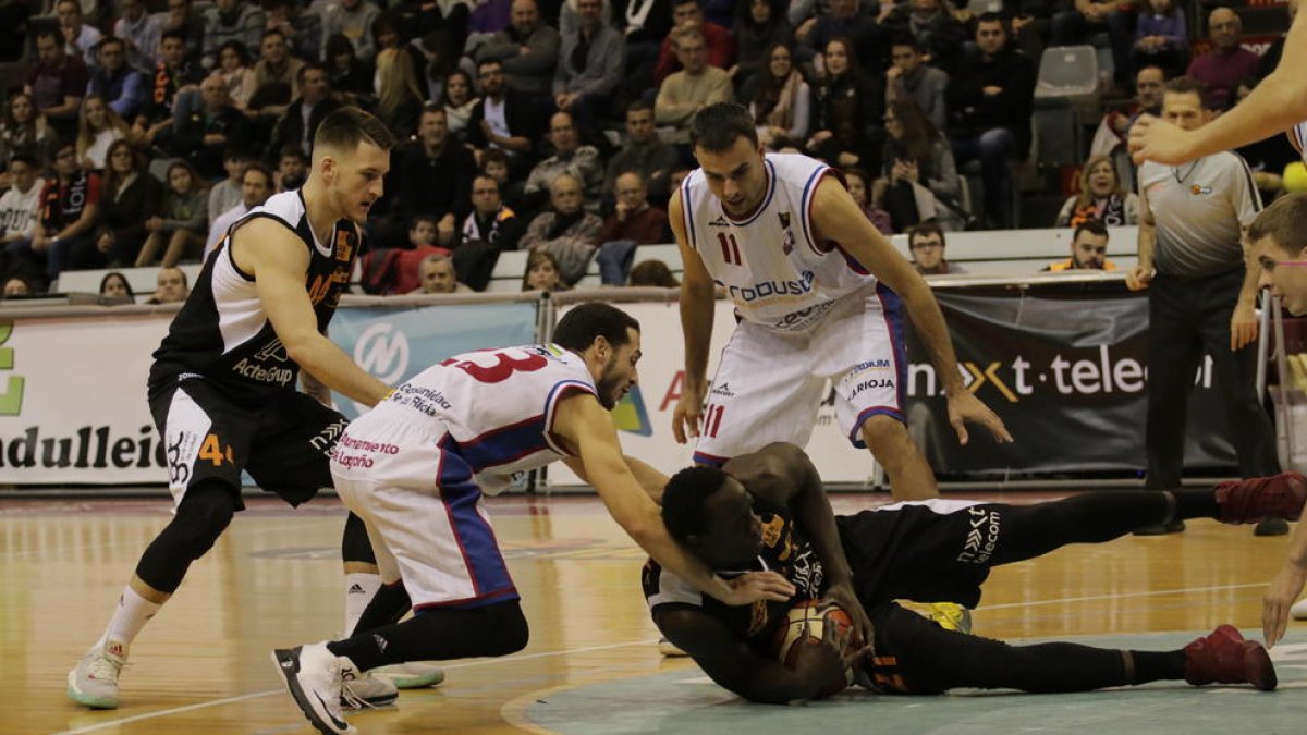 Mbaye aconsegueix una pilota a terra, davant de la presència d’un rival i del base Papantoniou, que debutava al Barris Nord.