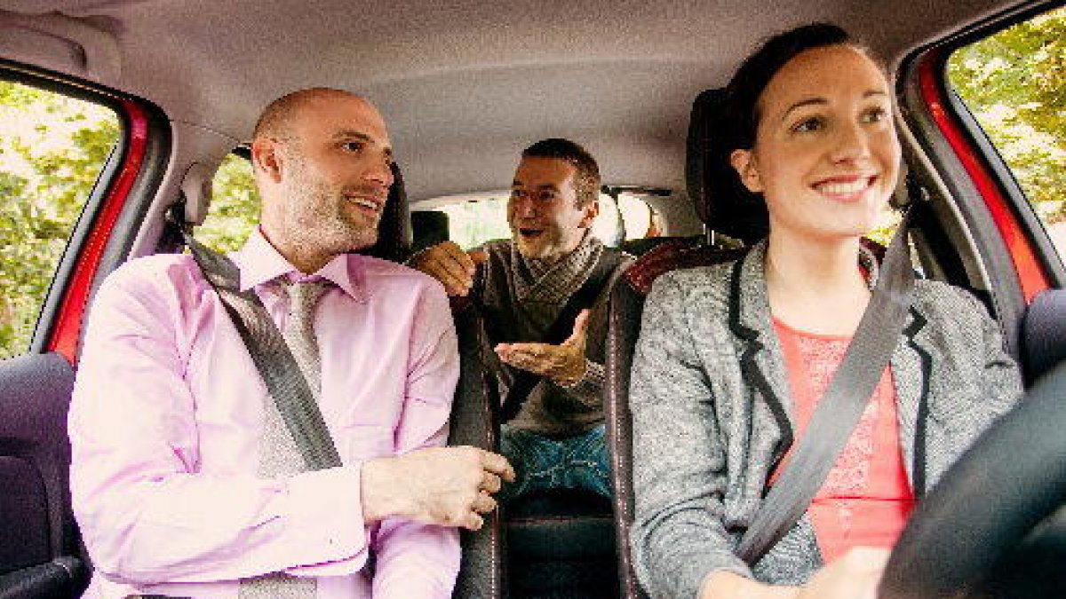 Tres passatgers compartint un vehicle.