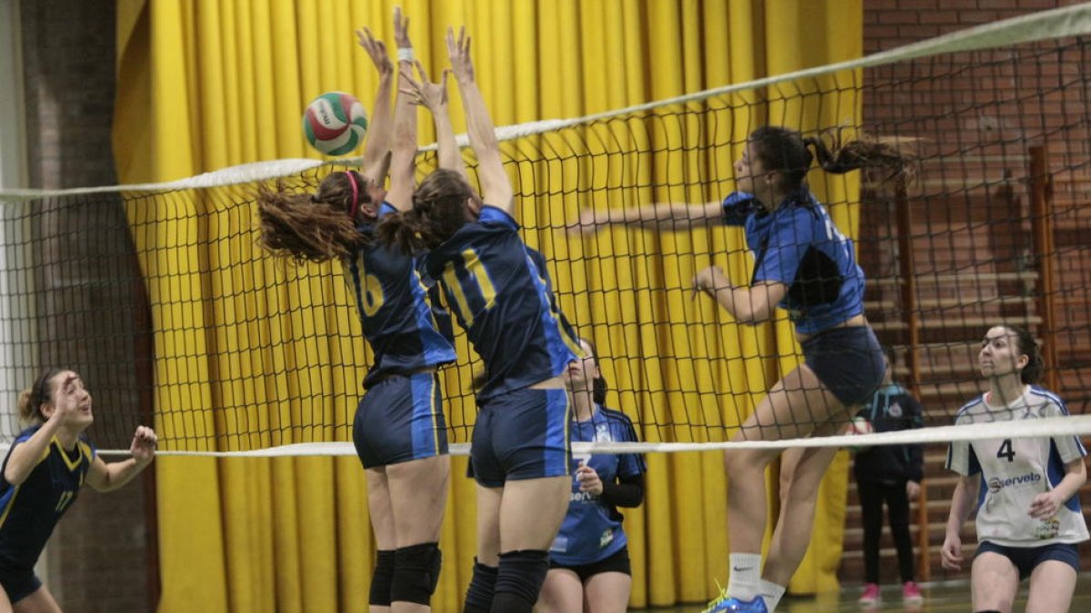 Les jugadores de l’Esplugues intenten bloquejar un atac del CECELL.