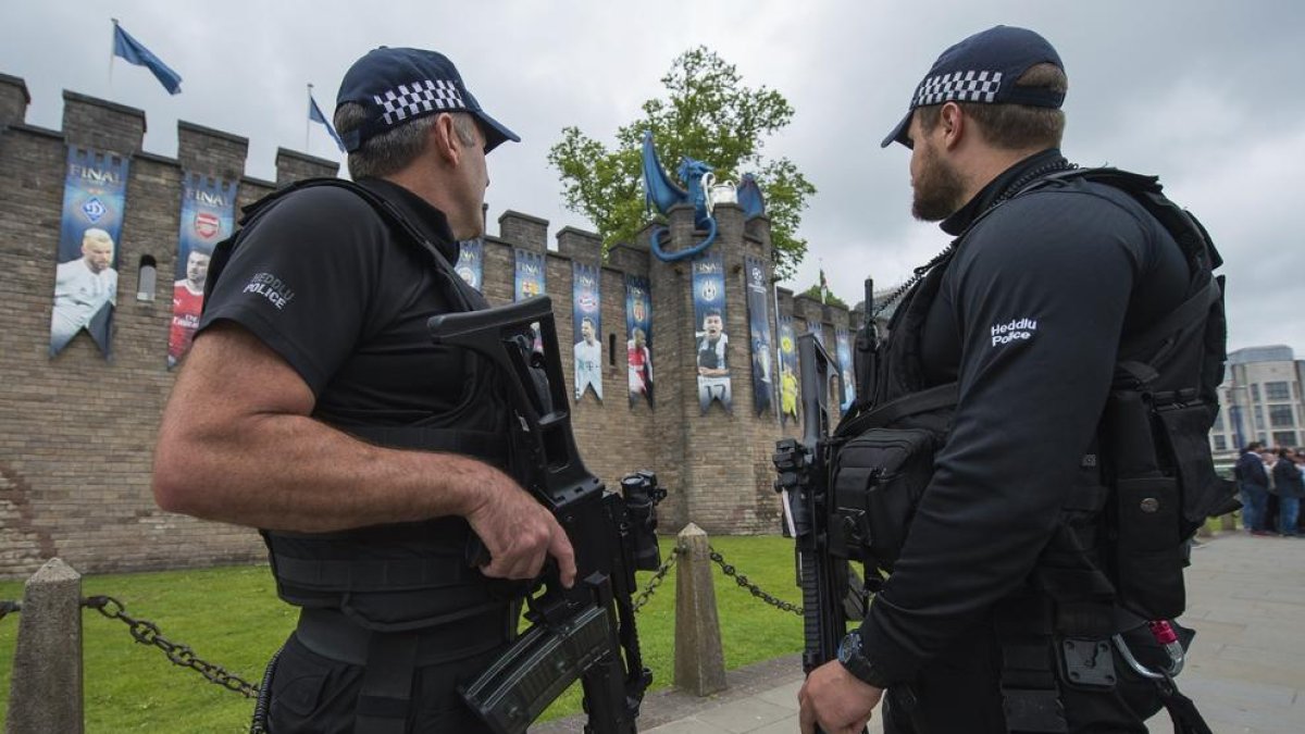 Dos policies, ahir a Cardiff, davant de nombrosos cartells que recorden el partit que es disputa aquesta nit.