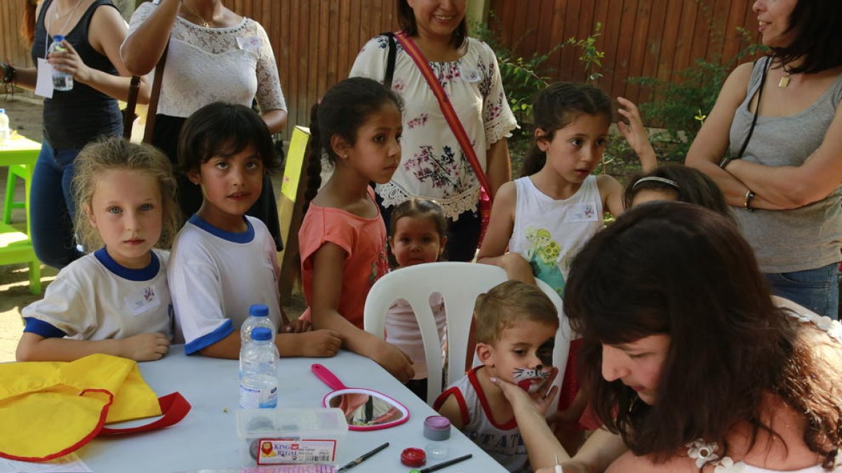 Varios niños esperan para participar en el taller de maquillaje.