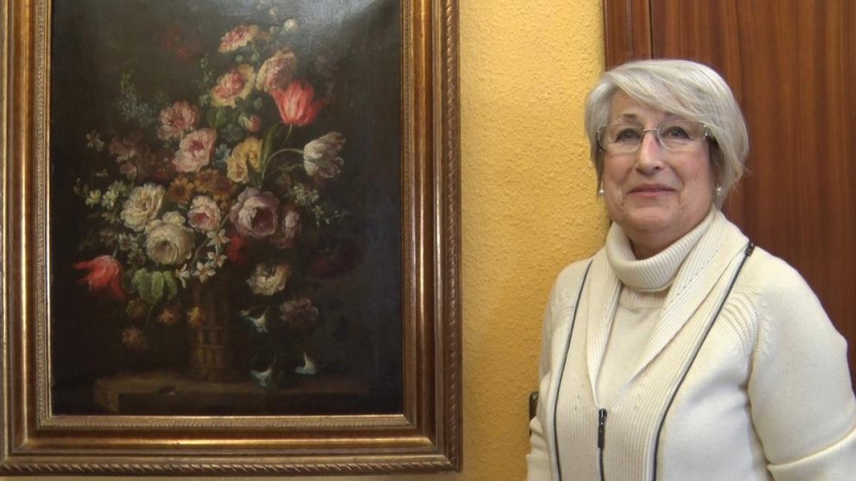 Rosa M. Martorell, de Cervera, al costat del quadre que ha recuperat del seu pare, Josep Martorell.