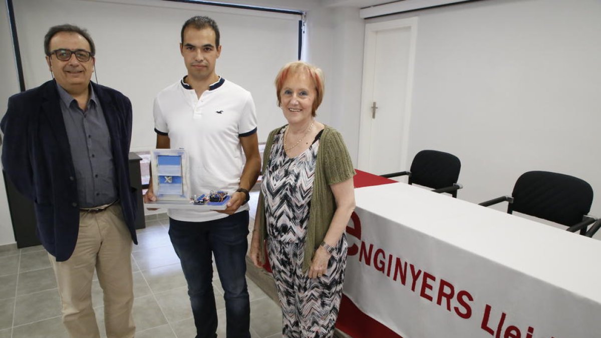 Adrià Domènech, al centre, mostra el projecte fotovoltaic que ha dissenyat.