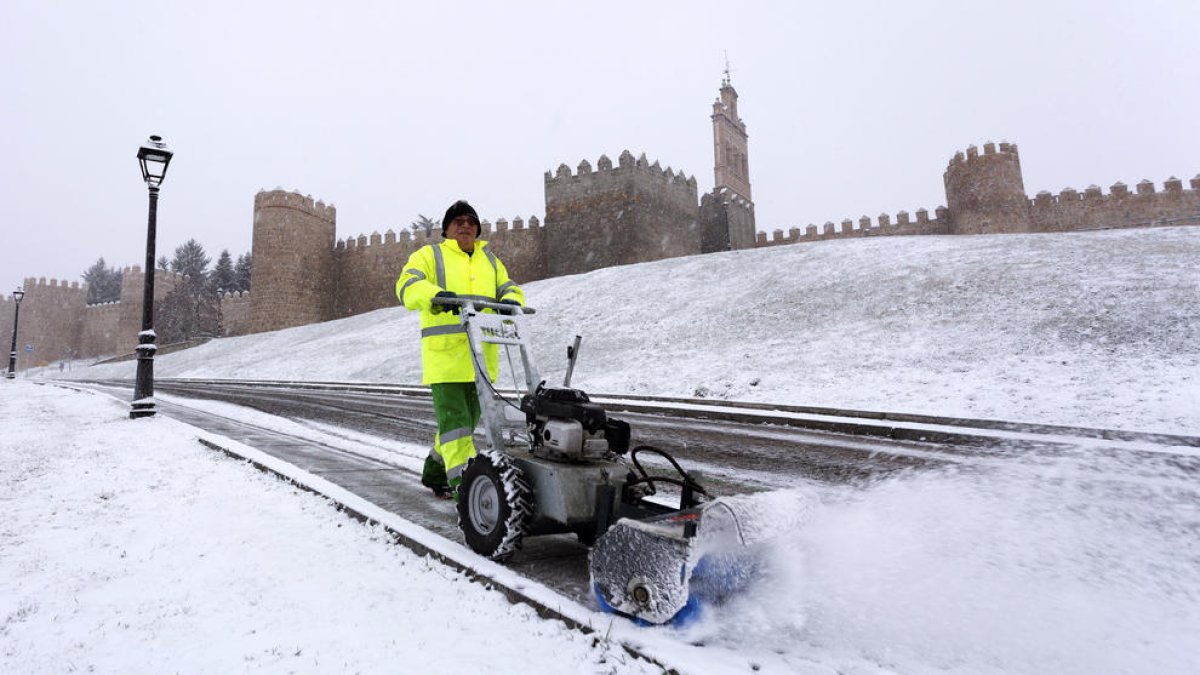 Un operari retira la neu caiguda durant la nit a Àvila.