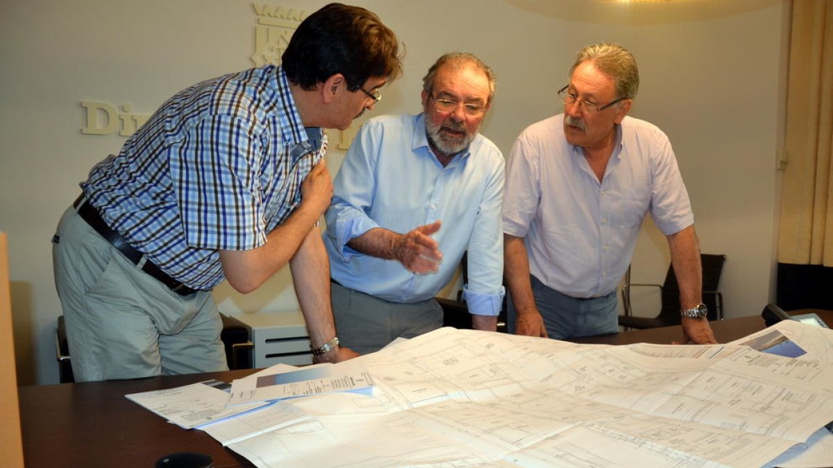 El president de la Diputació, Joan Reñé, al centre, repassa plànols del projecte amb tècnics.