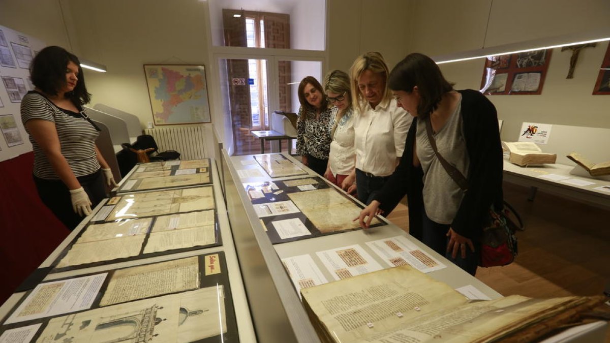 Responsables de l’Arxiu Capitular de Lleida i visitants, ahir, a l’exposició de documents del fons.
