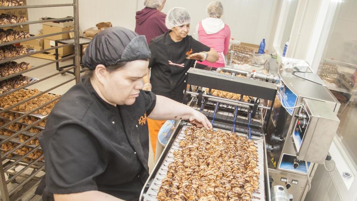 Una trabajadora del obrador con las galletas que elaboran.