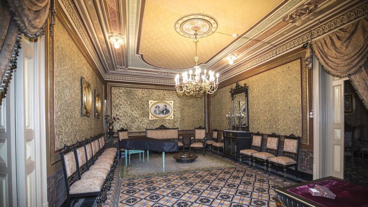 Un dels salons de la casa senyorial Duran i Sanpere de Cervera i, a la dreta, la capella privada de l’edifici, amb els personatges de les pintures inspirats en la mateixa família.