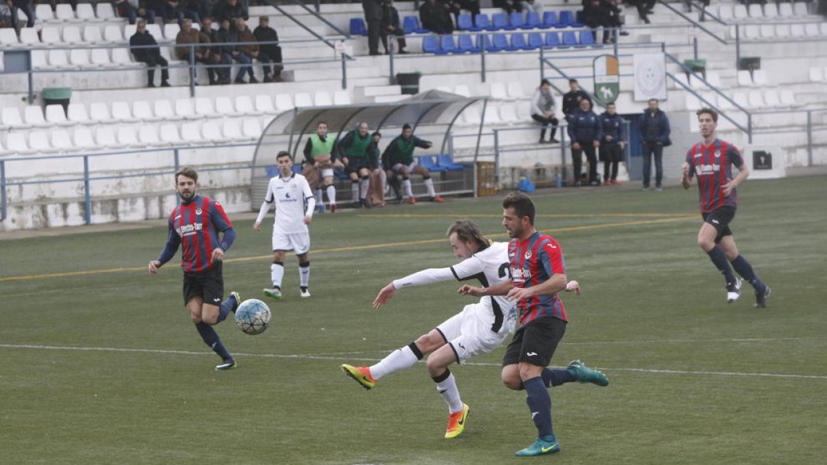 Un jugador del Borges colpeja la pilota davant de l’oposició d’un rival.