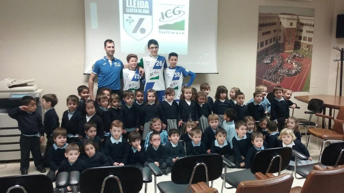 Marc Soler i tres jugadors del club posen amb alumnes de preescolar de Lestonnac.