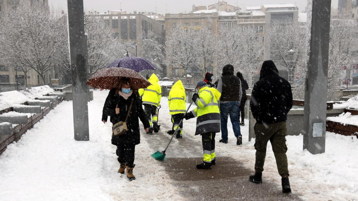 Operaris escombraven la neu de la passarel·la del Liceu Escolar de Lleida.