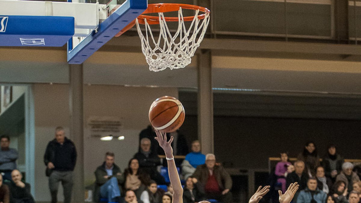 Belén Arrojo llança a cistella davant de la nord-americana Roneeka Hodges, jugadora del Mann Filter.