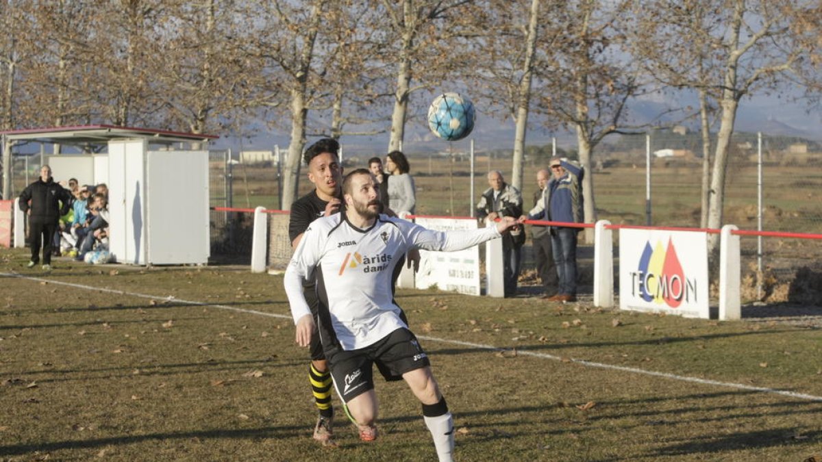 Una acción del partido con un jugador de cada equipo pugnando por el balón.
