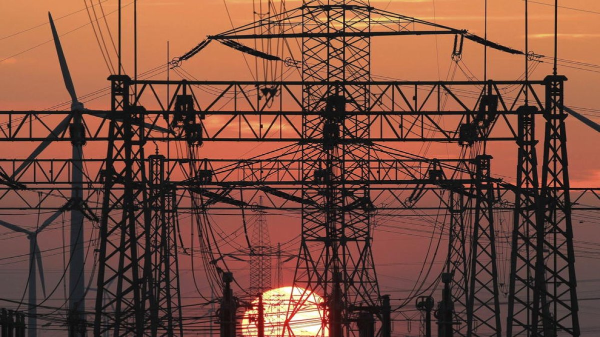 A la imatge, una posta de sol darrere la línia elèctrica.