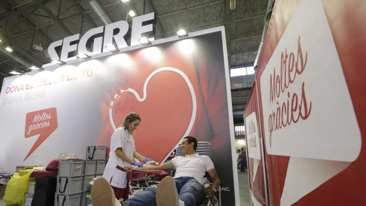 Una persona donando sangre en el estand de SEGRE en la Fira.