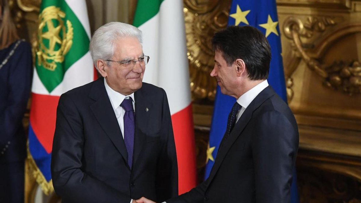 Giuseppe Conte  estrecha la mano del jefe del Estado, Sergio Mattarella, tras tomar posesión.