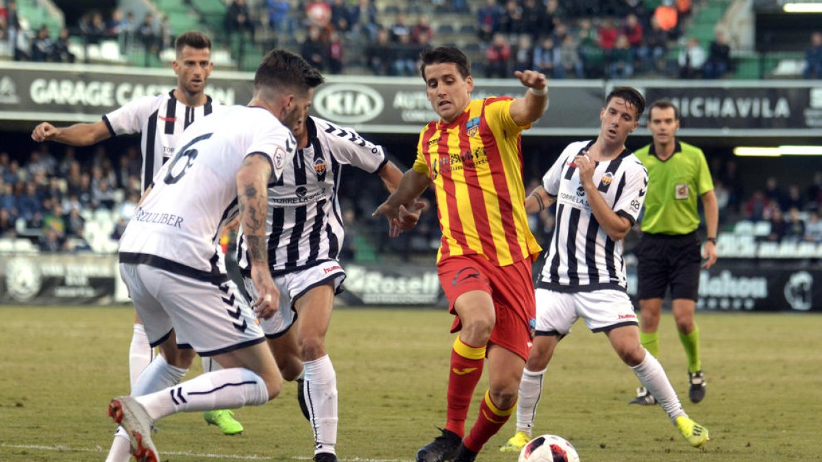 Juanto Ortuño controla la pilota pressionat per diversos futbolistes del Castelló, ahir durant el partit a Castalia.
