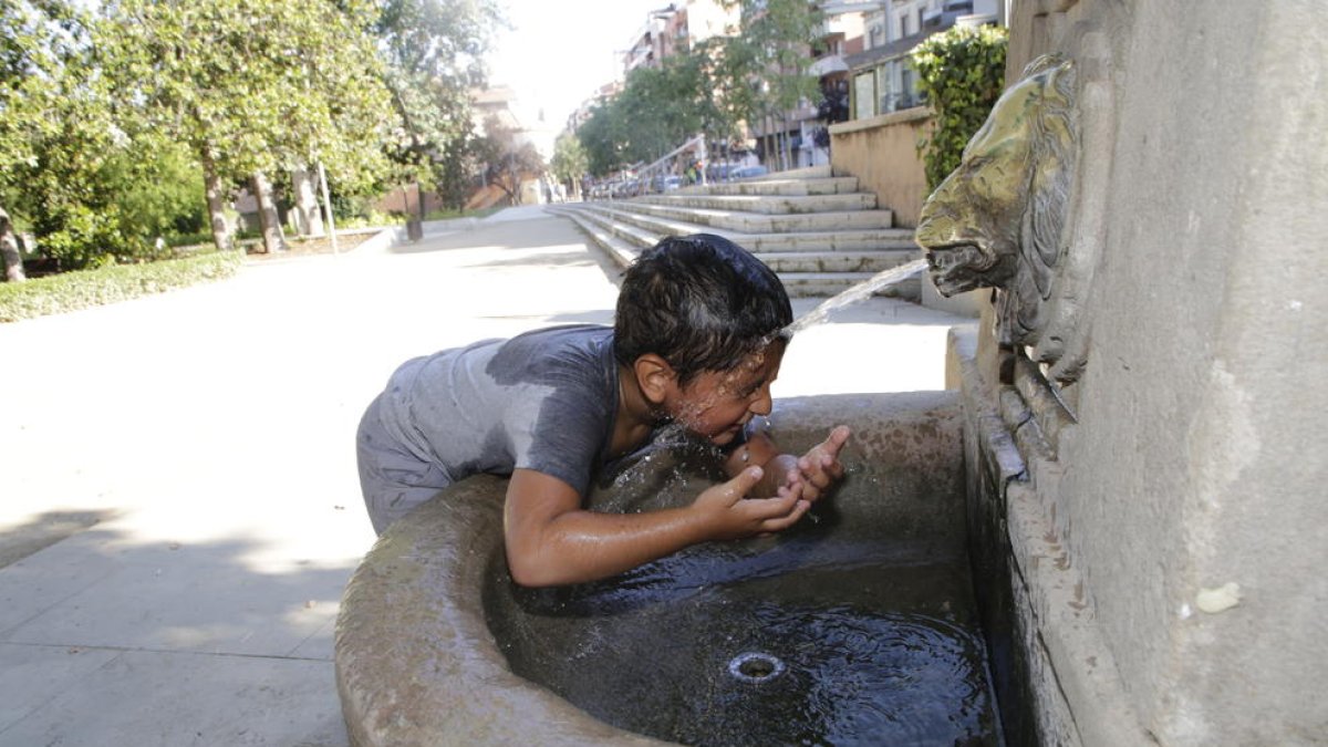 Un niño se refrescaba ayer en una fuente de Lleida.