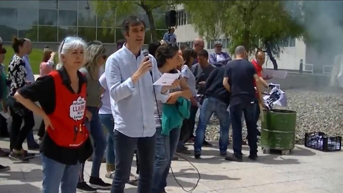 Los trabajadores, en la concentración de ayer, con la hoguera.