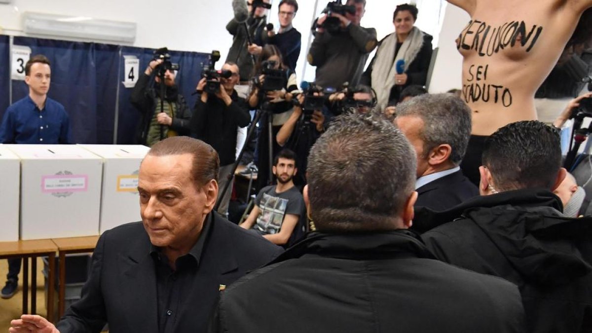 Silvio Berlusconi fue sorprendido por una activista de Femen cuando iba a depositar su voto.
