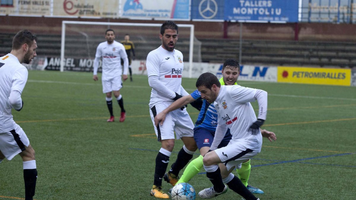 Un jugador del Borges intenta driblar a un jugador del Igualada ante un compañero.