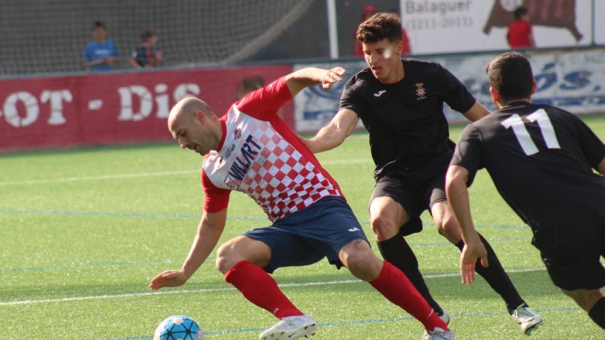 El jugador del Balaguer Adrià, autor de dos gols ahir, intenta driblar dos jugadors del Valls en una de les jugades del partit d’ahir.