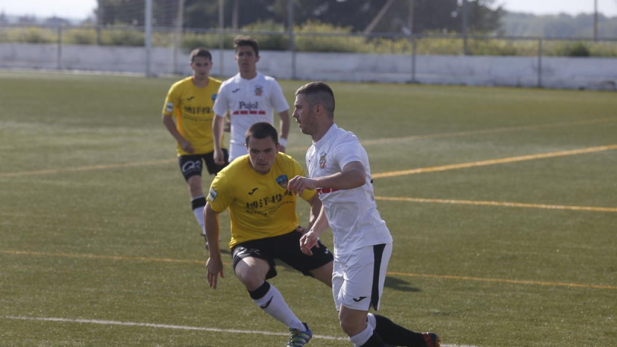 Un jugador del Borges, pressionat per un del Lleida B, intenta passar la pilota a un company.