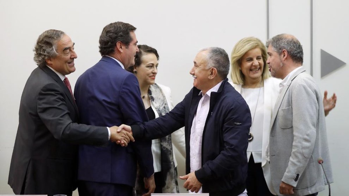 Patronals i sindicats es donen la mà després de la firma de l’acord.