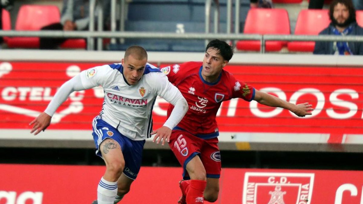 Jorge Marcos Pombo disputa el balón con el defensa del Numancia Markel Etxeberría.