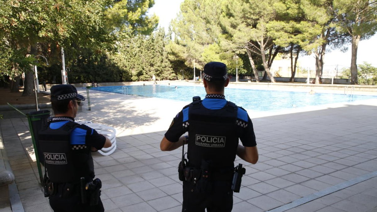Dos agentes de la Guardia Urbana, ayer en las piscinas de Gardeny.