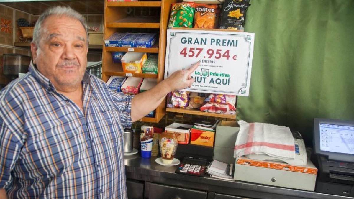 Jesús Morros, propietario del bar donde se selló el boleto ganador, mostrando el cartel del premio.