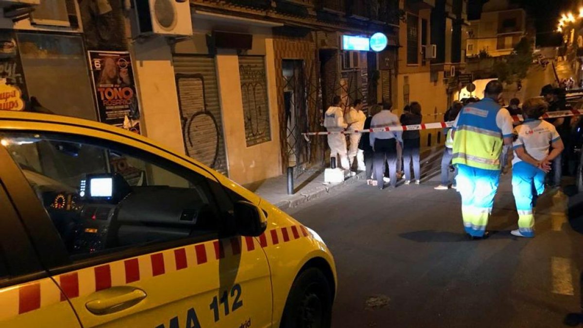 Investigadores y sanitarios junto al local del barrio madrileño de Tetuán, en la madrugada de ayer.