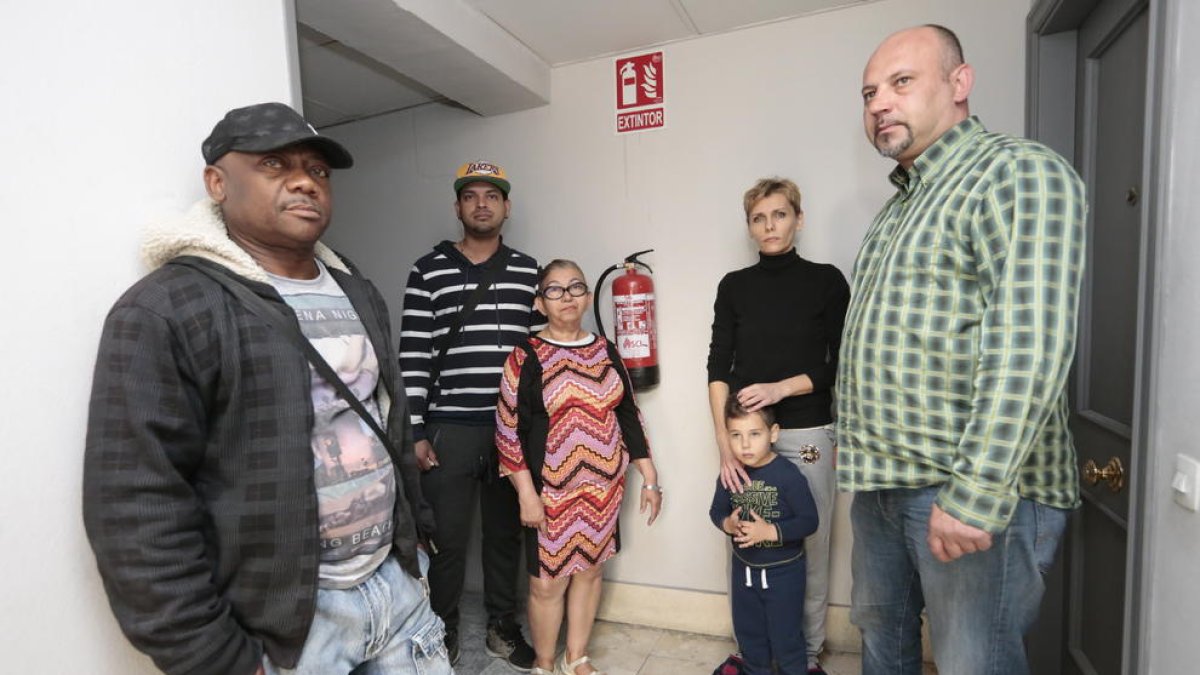 Un grupo de vecinos del inmueble en uno de los pasillos del edificio, todo el piso está sin luz ni agua.