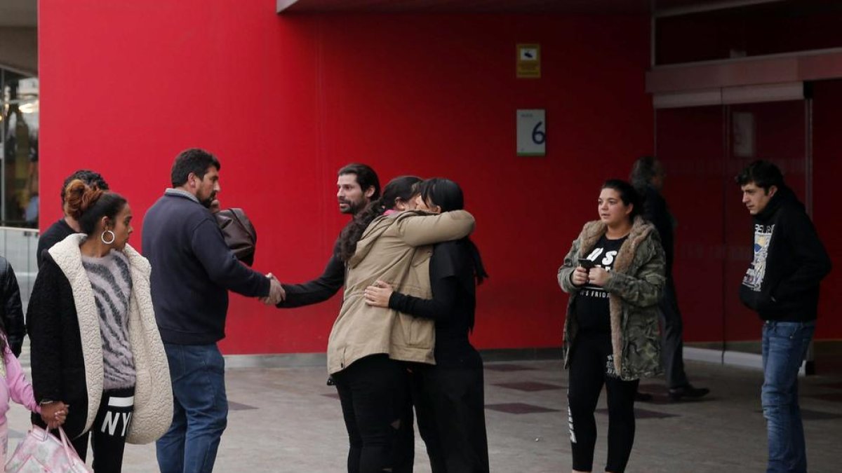 Familiares y amigos del interno de la prisión conversan en la entrada del Hospital de Oviedo.