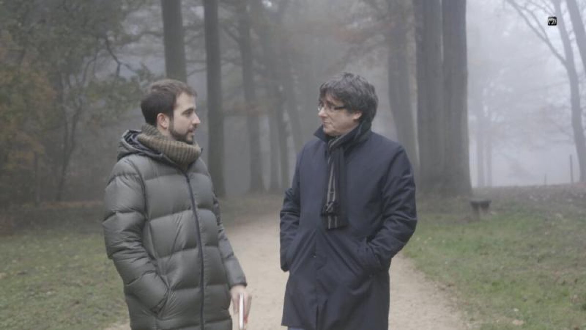 Puigdemont i Ustrell conversen passejant per un bosc.