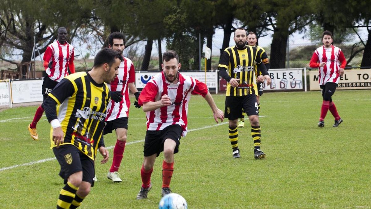 Un jugador del Angulària recibe el balón ante la presión de un jugador del Barbens.