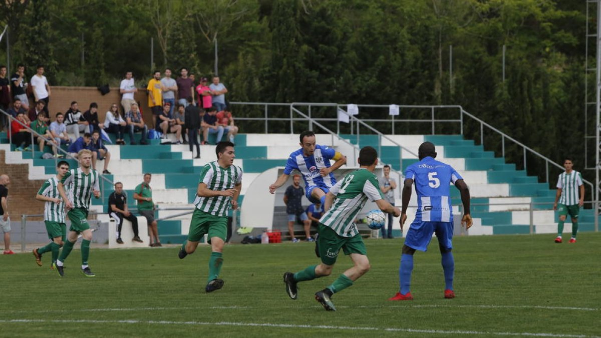 El capitán del Torregrossa intenta pasar el balón a un compañero bajo la presión de los rivales.