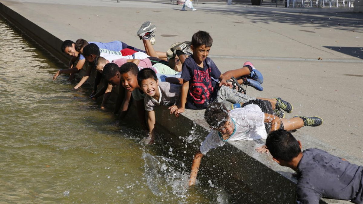 Els nens es refrescaven ahir a la font de la plaça del Clot de les Granotes de Lleida.