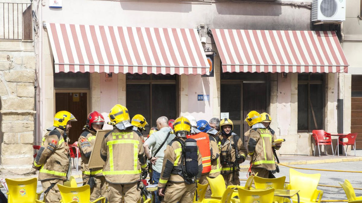 Efectivos de bomberos poco después de sofocar el fuego en el bar del centro de la localidad.