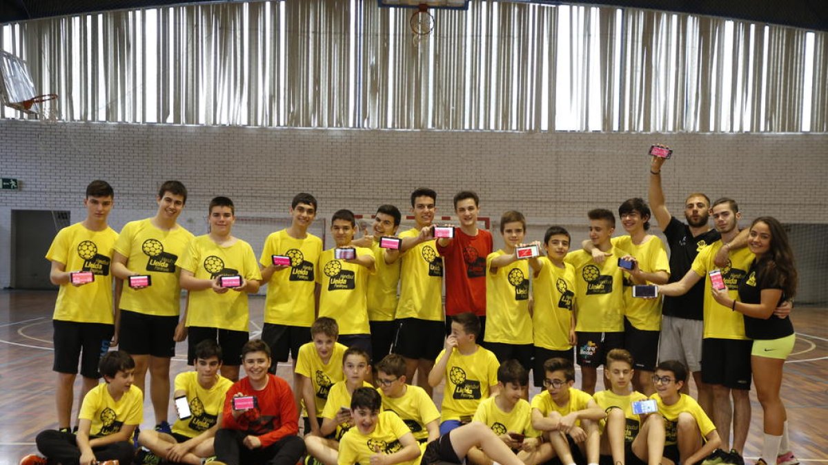 Jugadors de la base de l’Handbol Pardinyes mostren els mòbils amb l’aplicació.