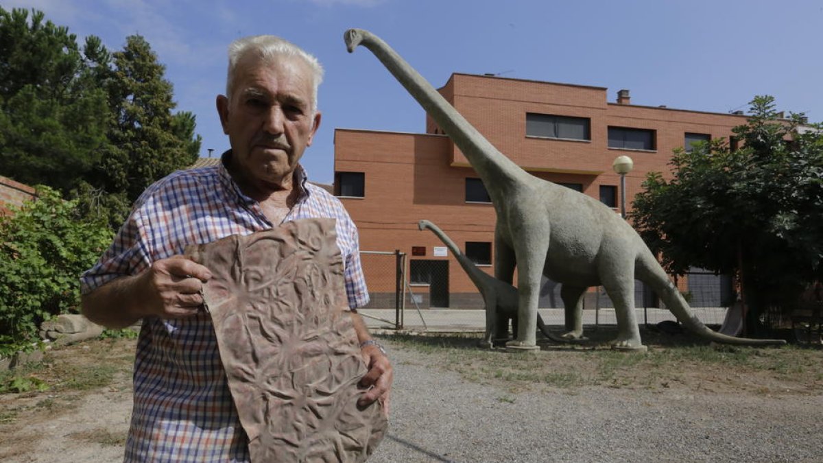 Antoni Gené, con la pieza que usó para simular la piel rugosa de los dinosaurios en el cemento.