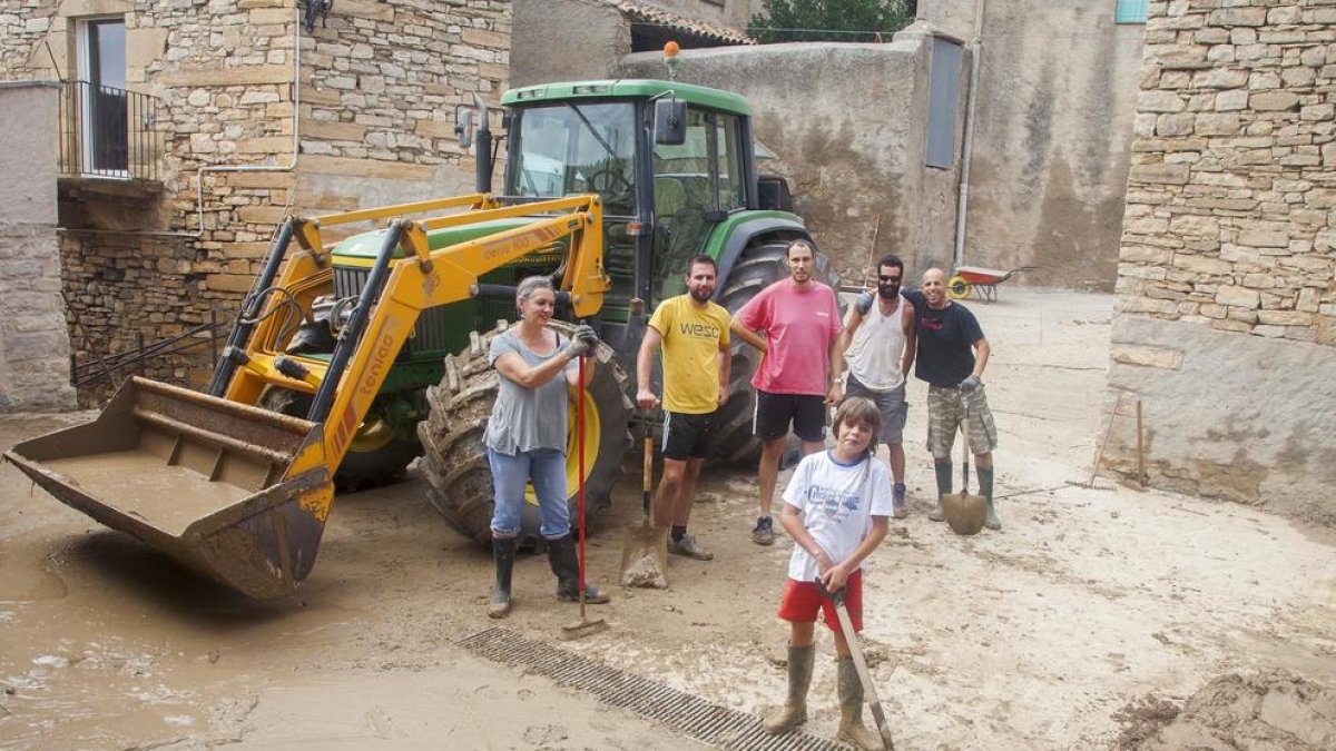 Vecinos de Vilagrasseta, en Montoliu de la Segarra, limpiaban ayer los restos de barro en la plaza de la Iglesia.