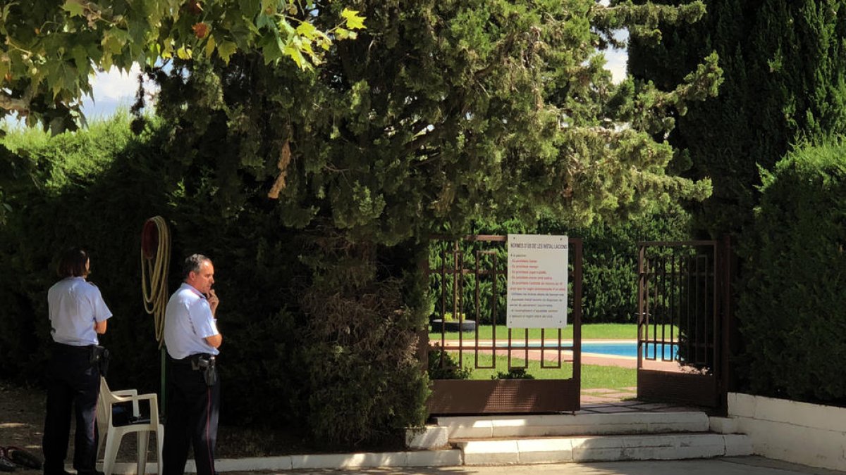 Dos agentes de los Mossos custodiando la entrada a la piscina de la entidad deportiva el día del suceso.