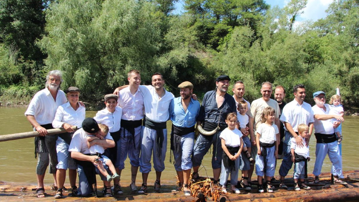 Foto de família de la vintena de raiers que han participat aquest any a Coll de Nargó en la construcció i la navegació d’aquestes barques de fusta.