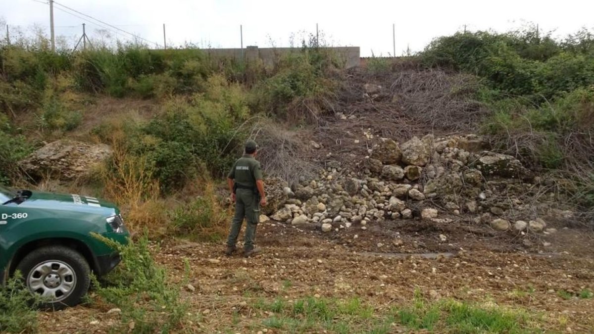 Los agentes rurales inspeccionando la balsa de purín.