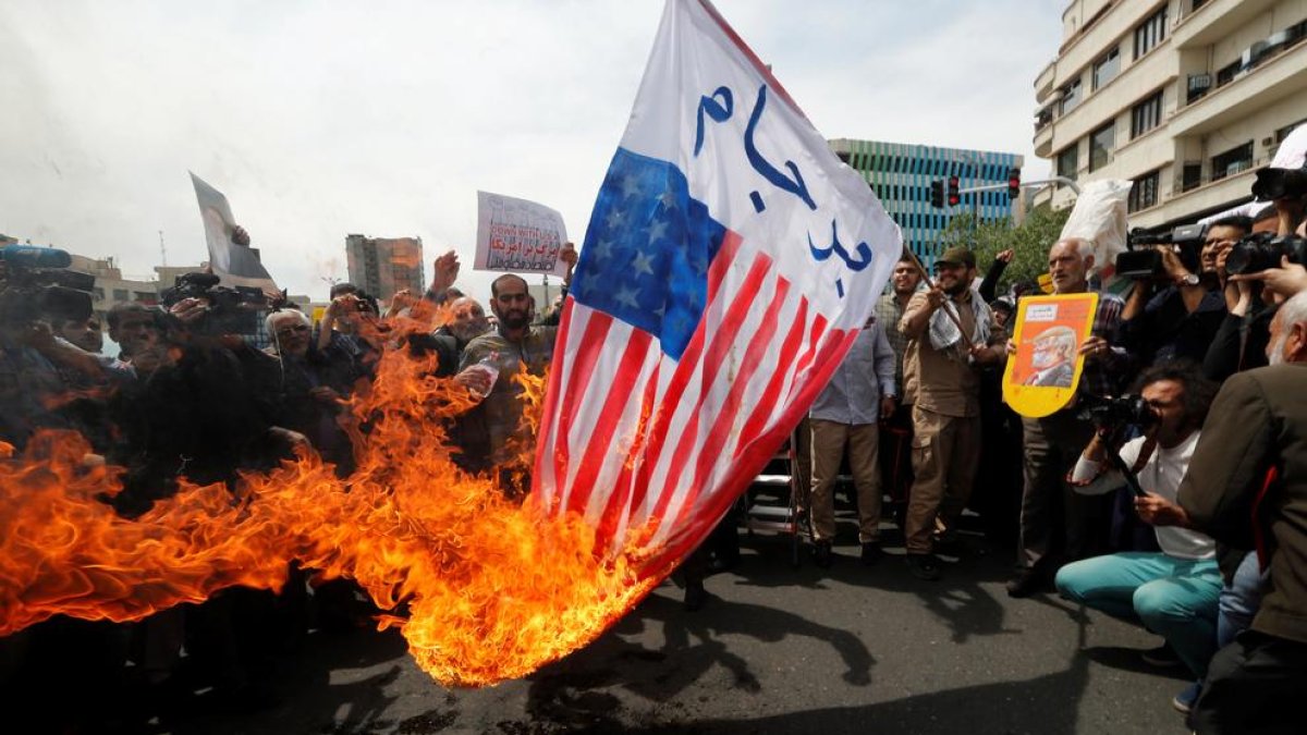 Iraníes queman banderas estadounidenses durante una manifestación contra la decisión de Trump.