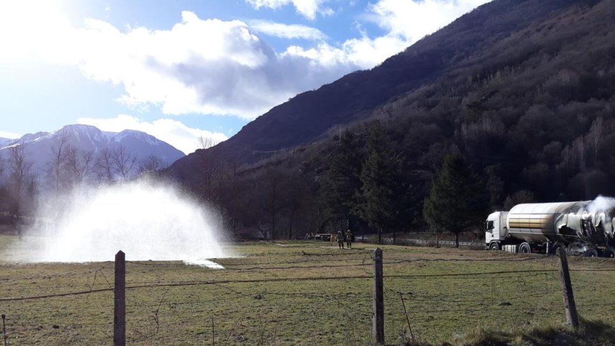 Un raig d’aigua va impedir la propagació del gas abocat (a terra, la fumarada davant l’aigua) pel camió cremat (a la dreta).