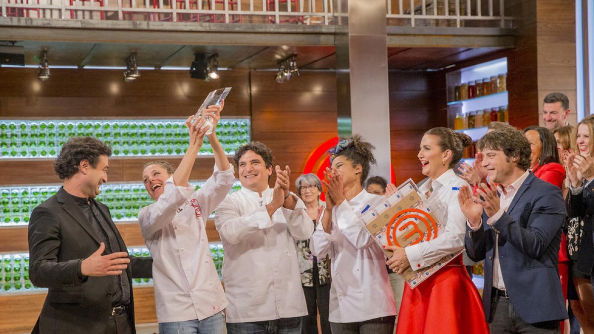 La ganadora levanta el trofeo ante el jurado y su compañera y amiga Ketty.